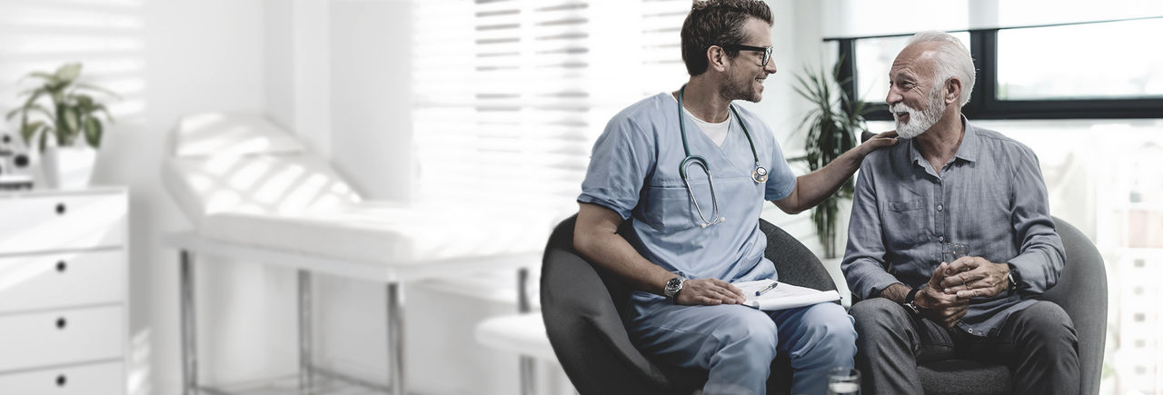 Doctor reassuring senior male patient during consultation